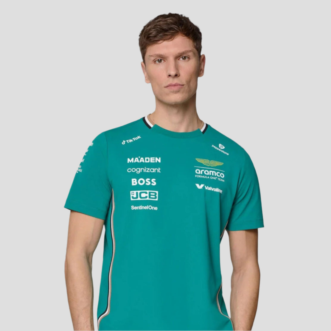 Man wearing a teal sports jersey with various sponsor logos on a gray background