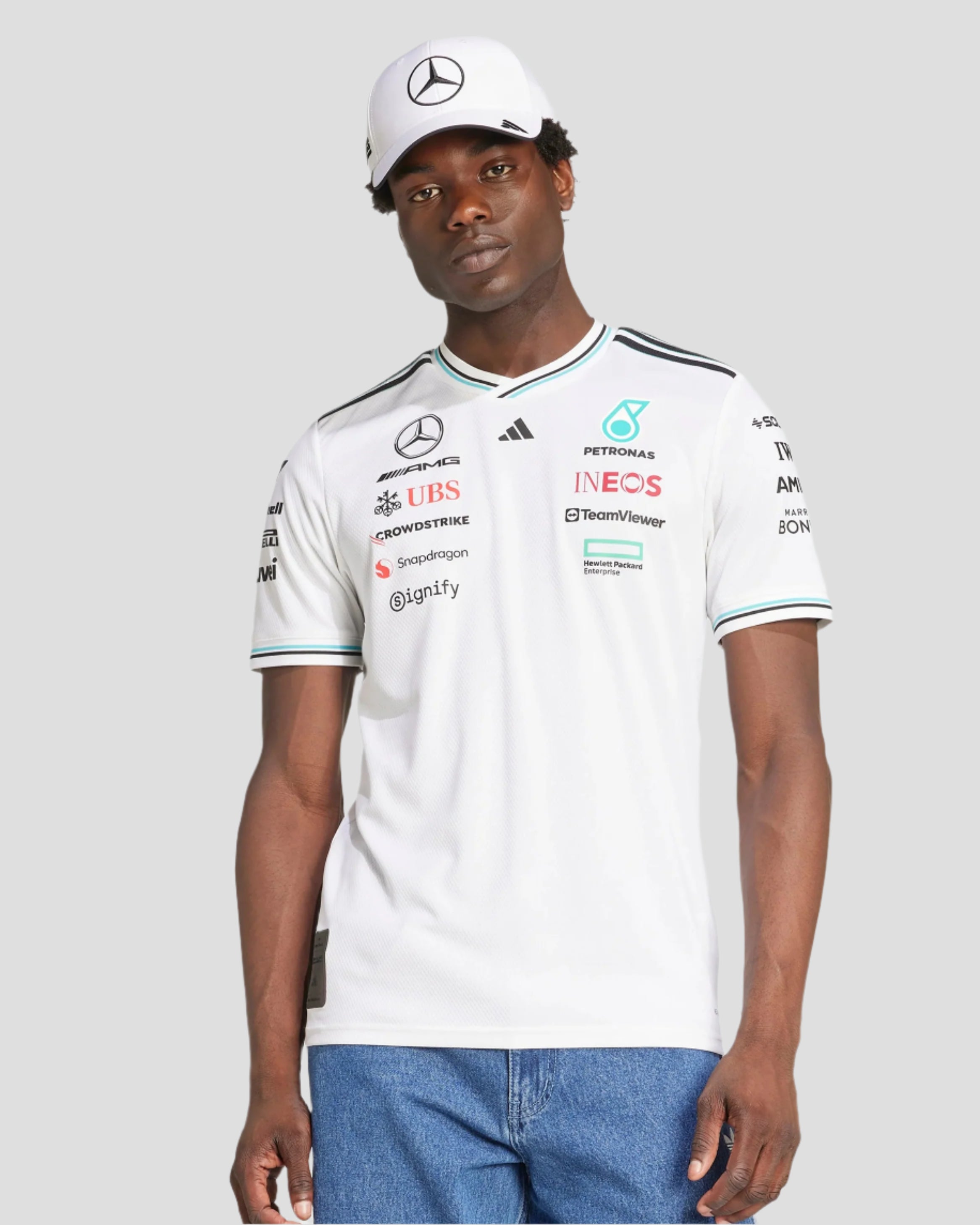 Person wearing a white Formula 1 team shirt with various sponsor logos on a light gray background