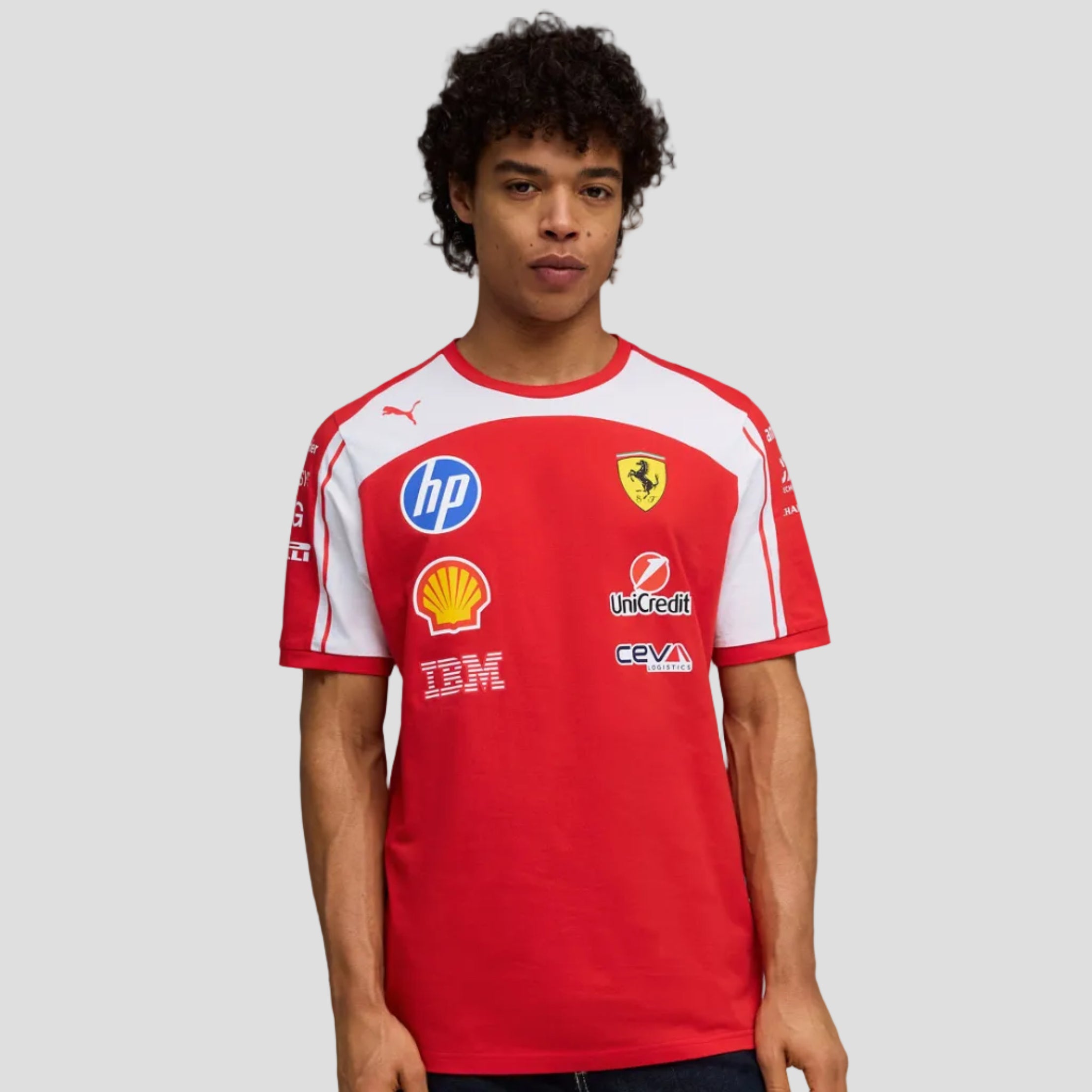 Person wearing a red sports jersey with various sponsor logos on a gray background