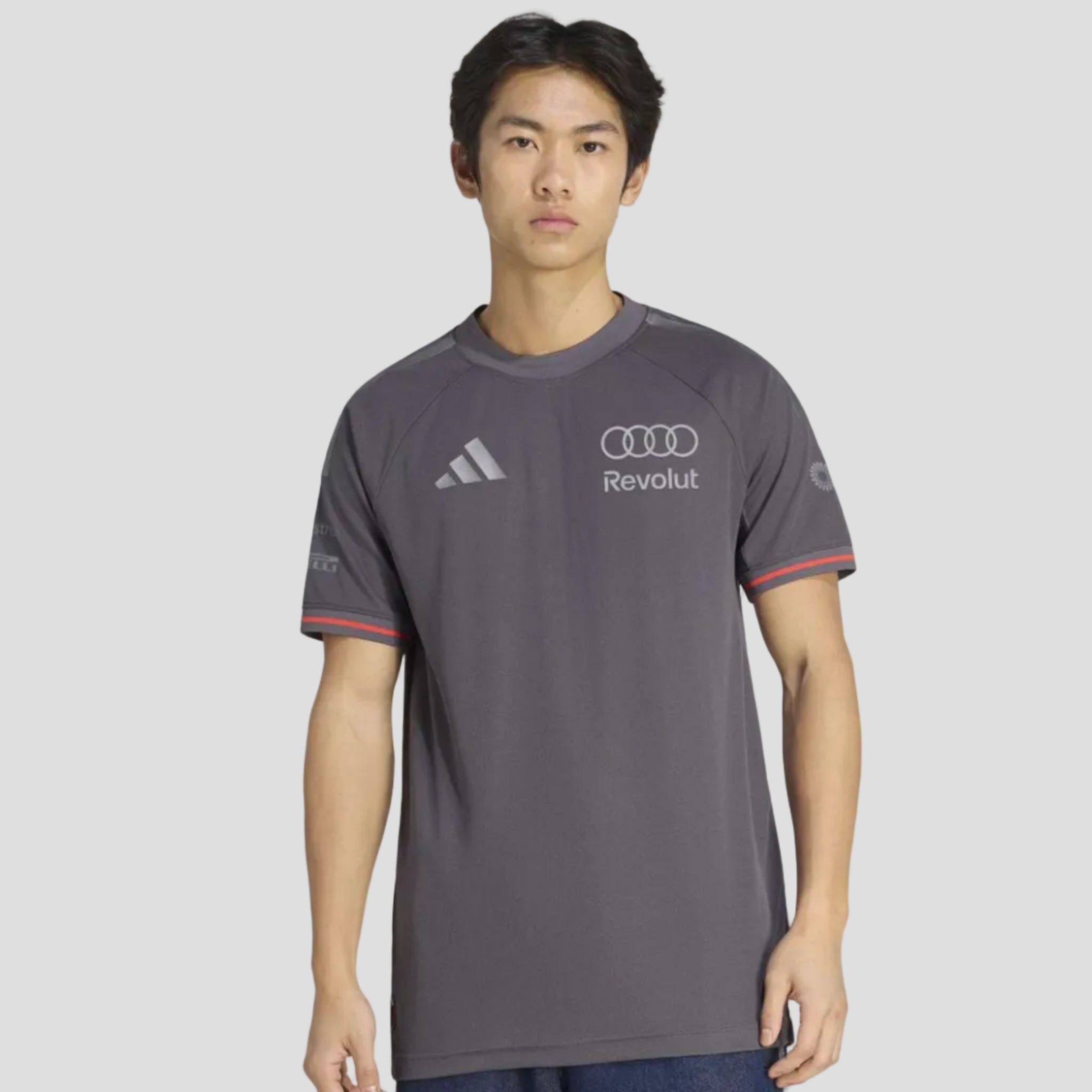 Person wearing a gray sports jersey with Audi and Adidas logos on a white background